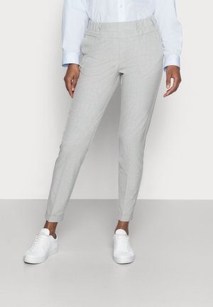 Hellgraue, taillierte Hose mit elastischem Bund, strukturiertem Stoff und Vordertaschen, kombiniert mit weißen Sneakers.