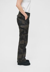 Camo cargo pants in donkergroen en zwart, gemaakt van stevig materiaal, met zijzakken en een recht gesneden pijp.