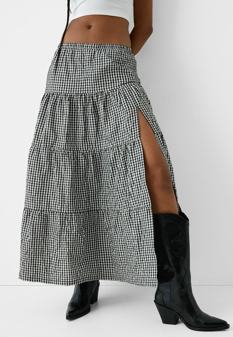 Sort og hvidt gingham maxi nederdel med lagdelt design, sideslids og elastisk talje, parret med knæhøje sorte støvler.