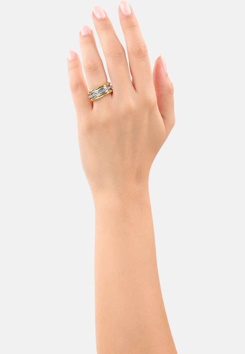 Gouden en zilveren ring gedragen aan een hand, met gelaagde banden en textuuraccenten. De vingernagels zijn natuurlijk, met een lichtroze glans.