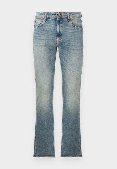Blå denimbyxor med utsvängda ben och ljus tvätt. Har fem fickor, knappstängning och subtil blekning mot fållen.