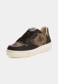 Baskets avec une tige en textile marron à motif arborant le logo Guess, accents en cuir noir, et une semelle extérieure beige épaisse.