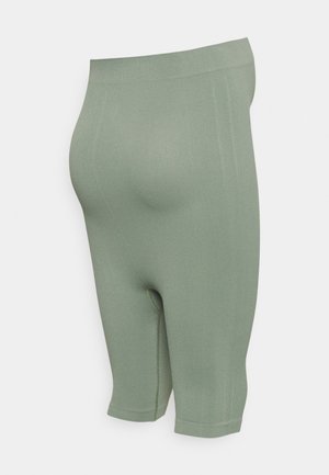 Calças de bicicleta verdes, com uma textura canelada e um design justo, até à metade da coxa, apresentando uma cintura elástica e detalhes de costura mínimos.