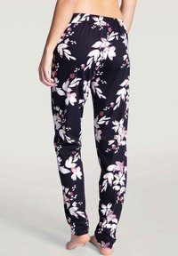 Floral pajama pants in navy fabric, featuring a smooth texture, elastic waistband, and white and pink flower patterns throughout.