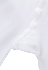 Weißer Stoff mit glatter Textur, der an der Kante genäht ist und ein kleines dreieckiges Ausschnittmuster an der Seite aufweist.