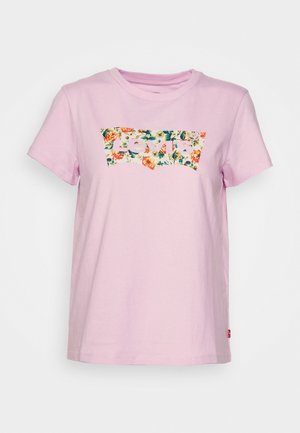 Jasnoróżowy T-shirt z krótkim rękawem z kwiatowym logo Levi's na piersi oraz małą czerwoną metką po lewej stronie szwu bocznego.
