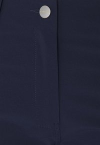 Navyblauwe broeken van gladde stof met een zilveren knop met "Mammut" gravure, rechte snit en subtiele stiksels.