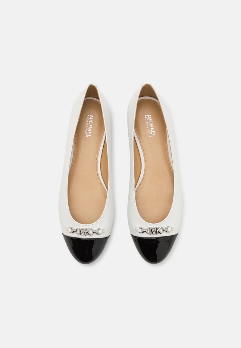 Bailarinas blancas con una puntera de charol negro, detalle de cadena plateada en el empeine y parte superior de cuero suave. El interior presenta un forro beige.