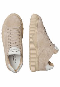 Sneakers in suede beige con suole in gomma testurizzate e rigate. Le caratteristiche includono lacci piatti, branding interno e un design minimale.