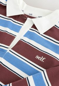 Polo de rugby à col avec des rayures horizontales en bordeaux, bleu, blanc et noir, présentant un logo "self." blanc sur la poitrine.