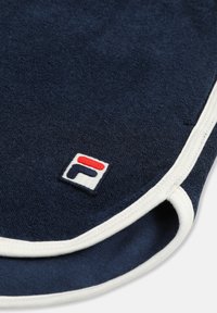 Marineblauwe handdoek met witte bies en een klein geborduurd logo in rood, wit en marineblauw nabij de hoek.