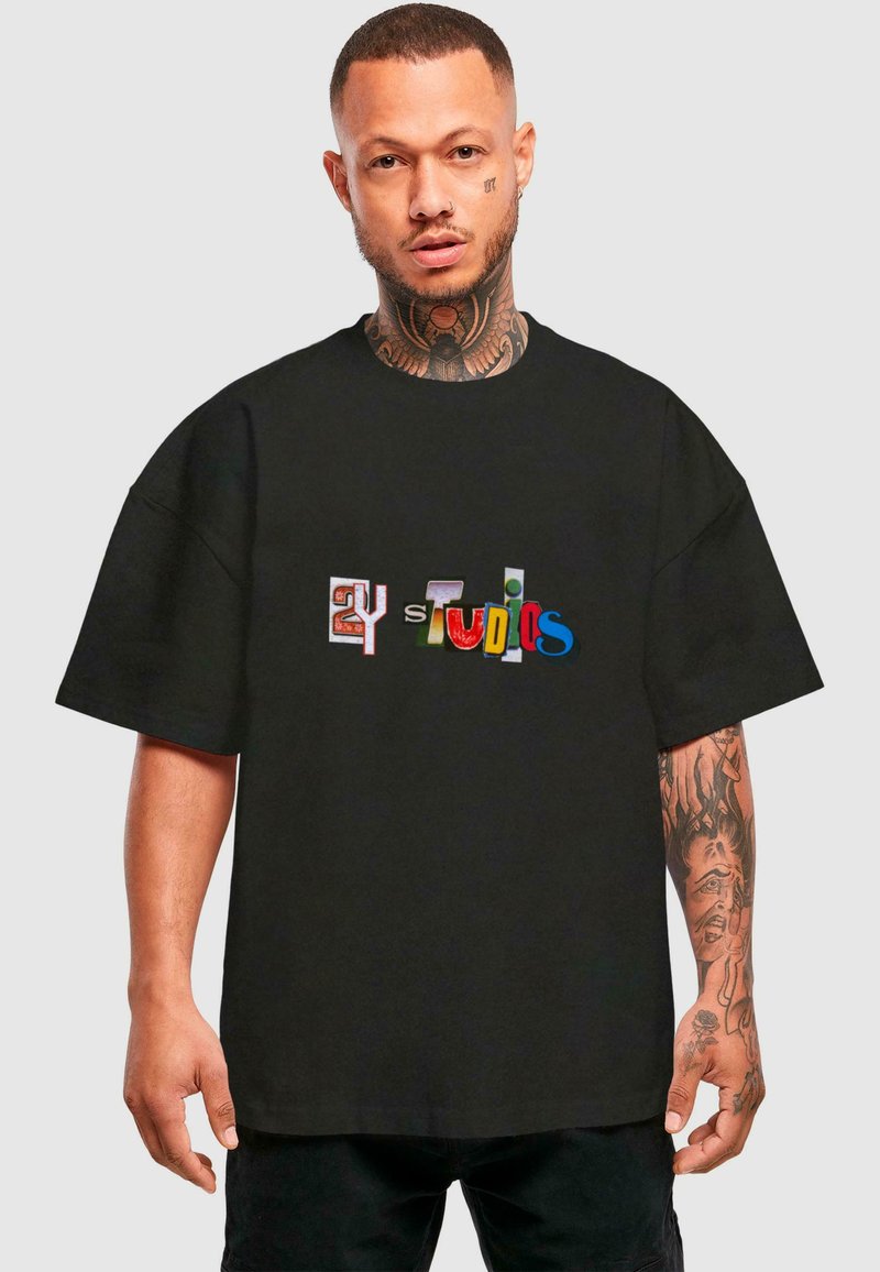 Sort t-shirt med løstsiddende pasform, prydet med multicoloreret tekst i forskellige skrifttyper, som læser "2Y Studios." lavet af bomuldsstof med korte ærmer.