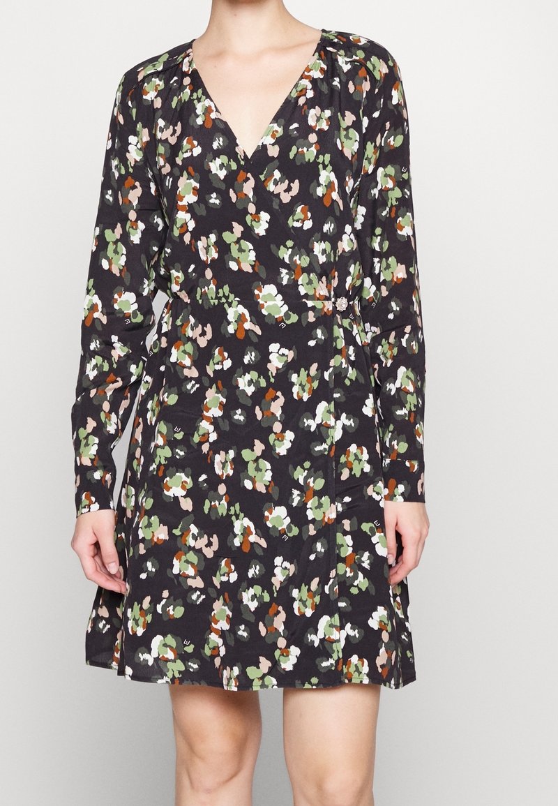 Czarna sukienka kopertowa w kwiatowy wzór w kolorach zielonym, brzoskwiniowym i białym. Posiada długie rękawy i głęboki dekolt w serek. Wykonana z lekkiego materiału.