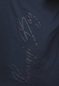 Navy blue fabric with embossed text, featuring a textured surface. The design has a clean look with no additional accents or patterns.