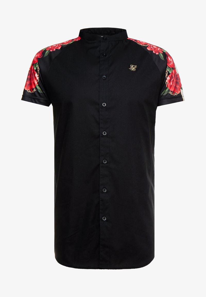 Camisa negra de manga corta con acentos florales en los hombros. Cuenta con un cierre frontal de botones y un cuello mao. Detalle del logo en dorado.