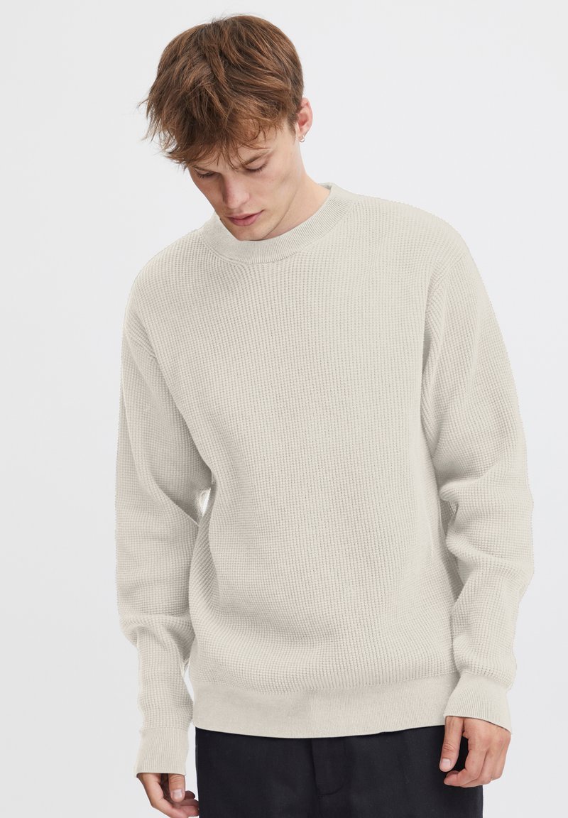 Hellbeige Waffelstrick-Pullover mit langen Ärmeln, gerippten Bündchen und rundem Ausschnitt. Weiche Textur, lockere Passform, minimalistischem Design.