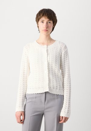 Witte gebreide cardigan met een gestructureerd zigzagpatroon, gegolfde randen en knoopsluiting. Gemaakt van lichte stof, met lange mouwen.