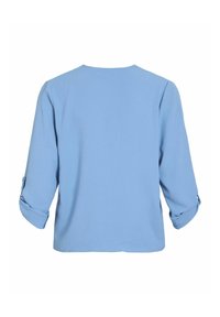 Camicia azzurro chiaro con maniche a tre quarti, texture morbida, scollatura rotonda e polsini arrotolati. Design semplice senza decorazioni.