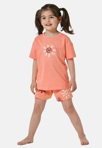 Koronkowy t-shirt bawełniany w kolorze koralowym z graficznym wzorem słońca oraz pasujące szorty z kwiatowymi wzorami. Krótkie rękawy, luźny fason i miękka tekstura.