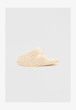 Cremefarvede slippers lavet af tekstureret, fluffy materiale med åben bagside og flad sål. Blød og hyggelig finish.