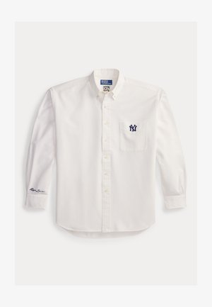 Λευκό πουκάμισο με μακριά μανίκια και κουμπιά, γιακάς με κουμπί, ναυτικό μπλε λογότυπο NY στην τσέπη του στήθους και την υπογραφή Ralph Lauren στο αριστερό μανίκι.