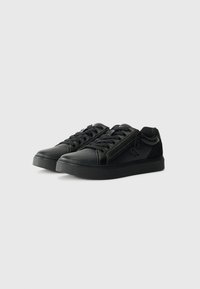 Tenis pretos feitos de material sintético texturizado, com design de atacadores, fecho lateral e sola de borracha com detalhe do logotipo.