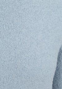 Lichtblauwe gebreide stof met een textuurafwerking, met een gelijkmatig patroon en een zachte uitstraling, geschikt voor kleding of accessoires.