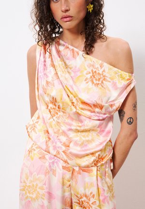 Mehrfarbigen Blumenkleid aus weichem, fließendem Stoff. Mit einem einseitigen Design und Blumenmustern in Pink, Gelb und Orange.