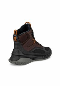 Scarpe da trekking marroni e nere con suola in gomma testurizzata, pannelli in rete, dettagli arancioni, collo imbottito e un sistema di allacciatura sicuro.