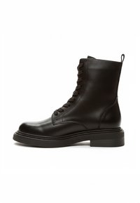 Schwarze Leder-Stiefeletten mit glatter Textur, abgerundeter Spitze, vorne geschnürt und robustem flachem Absatz. Absatzhöhe ca. 2,5 cm.