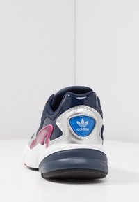 Navy mesh sneakers med silver- och rosa detaljer, med en vadderad krage, texturerad yta och blå logotyp på hälen.