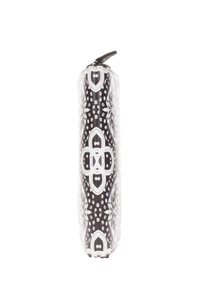 Pochette cylindrique noir et blanc avec un motif symétrique de points et de motifs géométriques, fabriquée à partir d'un matériau lisse et dotée d'une fermeture éclair.