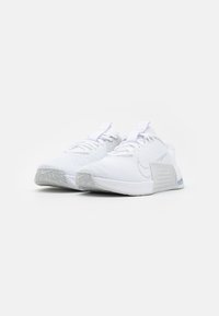 Witte sportieve schoenen met een bovenwerk van mesh, een gestructureerde zool en een strak ontwerp. Inclusief veters en een treklabel op de tong.