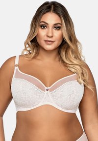Sostén de encaje blanco con detalles de malla transparente y un botón decorativo en el centro. Presenta tirantes ajustables y un patrón floral.