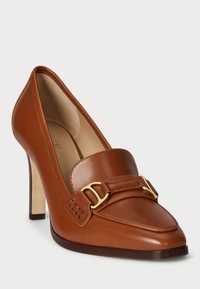 Καφέ δερμάτινο παπούτσι με ψηλό τακούνι, με μυτερή μύτη, φαρδιά λουρί με χρυσά αξεσουάρ και λεία υφή. Καουτσούκ σόλα για πρόσφυση.
