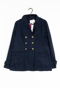 Námořnická modrá dvouřadá bunda se zlatými knoflíky, vybavená dvěma předními kapsami a klasickým límcem, vyrobená z lehkého materiálu.