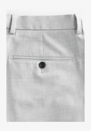 Helle graue Hose aus strukturiertem Stoff, mit einer Gesäßtasche mit schwarzem Knopfverschluss und einem rechteckigen, flachen Paspeldesign.