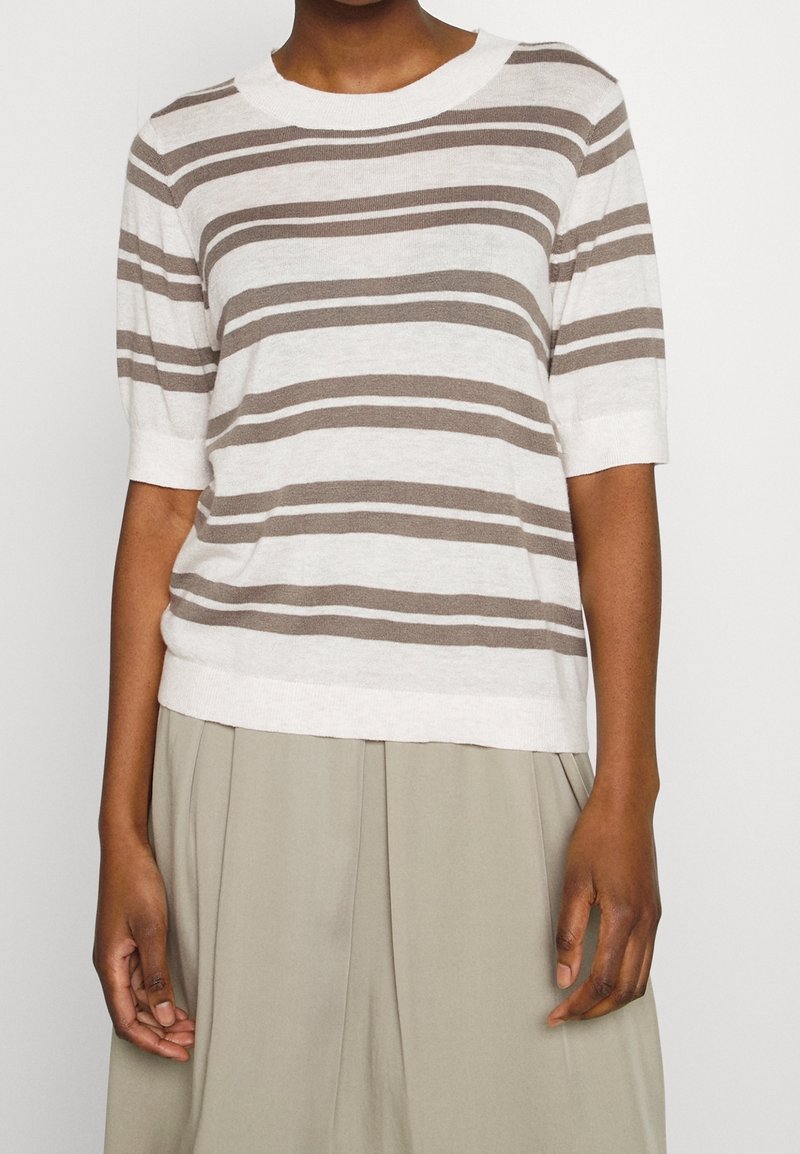 Beige und hellbraun gestreifter Strickpullover mit kurzen Ärmeln und rundem Halsausschnitt, getragen über einem hellbeigen Faltenrock.