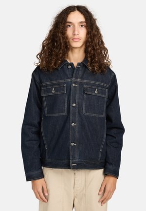 Veste en denim bleu foncé avec deux poches poitrine, fermeture par boutons et couture contrastante. Dotée d'un col et de manches longues.