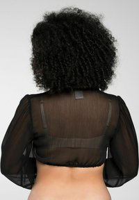 Schwarze, durchsichtige, kurz geschnittene Bluse mit langen Ärmeln, tailliertem Schnitt und dezenter gerippter Textur. Die Rückansicht betont den Ausschnitt und die Schulternaht.