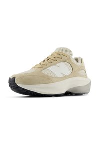 Beige sportcipő, amely ötvözi a velúr és a hálós anyagokat, oldalán fehér N logóval, textúrázott fűzőkkel és fekete gumitalppal.