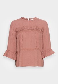 Blouse à manches longues rose blush avec tissu texturé. Présente des bordures en dentelle, des poignets à volants et une ouverture en trou de serrure à l'arrière. Coupe ample.