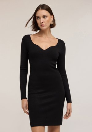 Robe noire ajustée avec des manches longues et un décolleté en forme de scallop plongeant. Fabriquée à partir d'un tissu lisse et extensible, conçue pour une silhouette épurée.