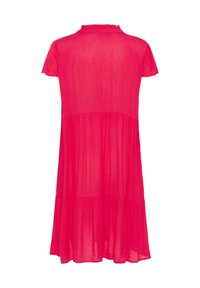 Pink, short-sleeved dress with a ruffled neckline, tiered design, and lightweight fabric. The hemline is slightly curved.