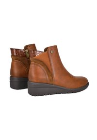 Botas de tobillo de cuero marrón con un upper texturizado de patrón de cocodrilo y una cremallera lateral, con un tacón bajo y suela de goma para mayor tracción.