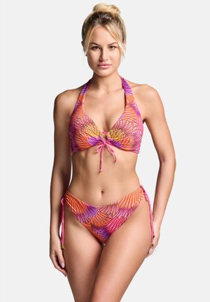 Kobieta z blond włosami związanymi w wysoki kok, prezentująca różowy, pomarańczowy i fioletowy bikini halter z wiązaniami po bokach, stojąca na białym tle.