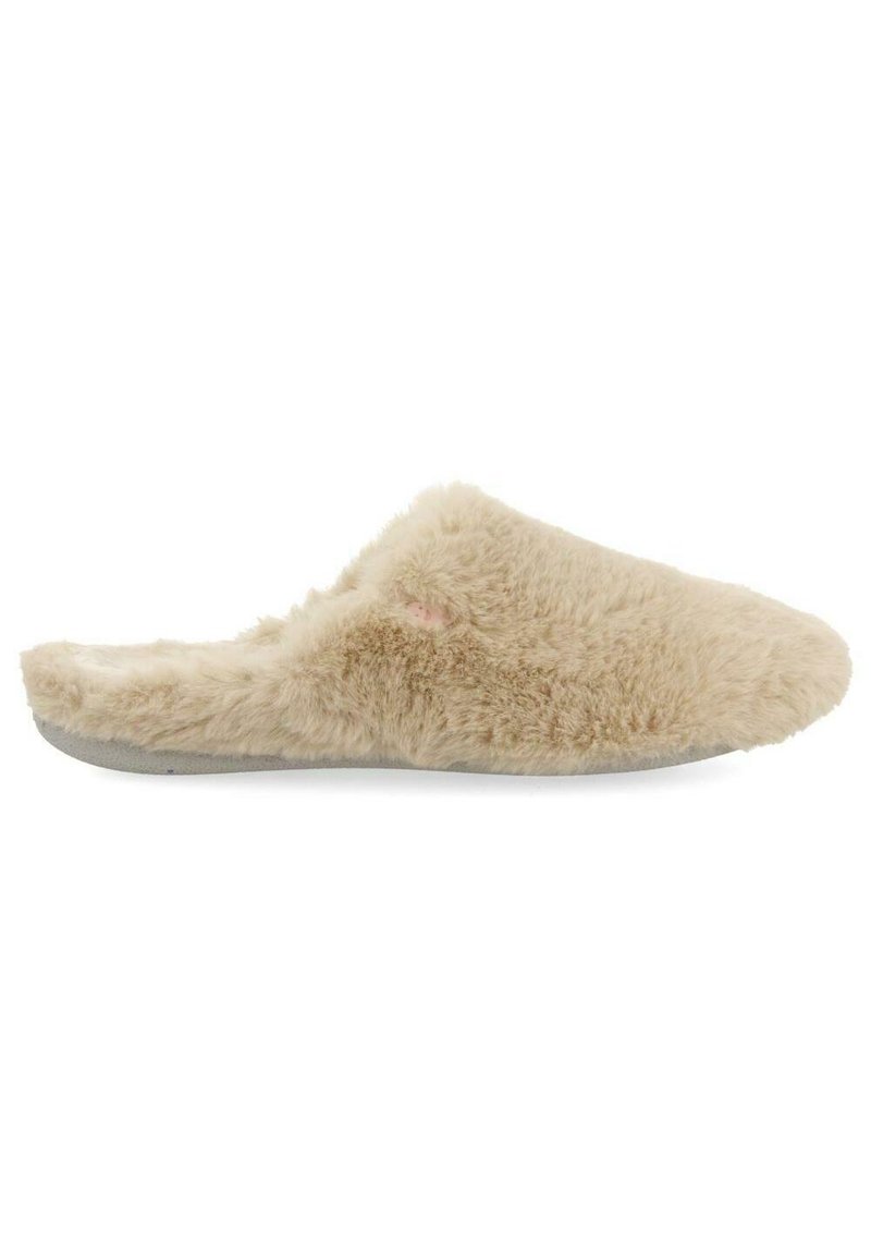 Chausson beige avec une texture douce et moelleuse, orteil arrondi et dos ouvert. Dispose d'une semelle extérieure grise pour plus de durabilité et de confort.