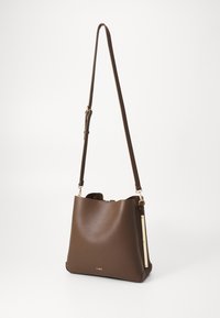 Borsa a secchiello in pelle marrone con texture liscia, tracolla regolabile e hardware color oro. Presenta una parte superiore aperta e un branding minimal.