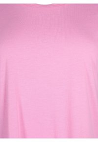 Camiseta de algodón de color rosa claro con una textura suave, que presenta un cuello redondo clásico y mangas cortas, diseñada para uso casual.