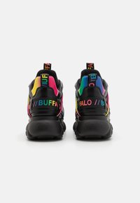 Black sneakers with a chunky sole, featuring colorful accents in pink, yellow, and blue, and branded heel tabs with bold text.